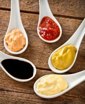 Sauces mixed in the ceramic spoons Stock Photos