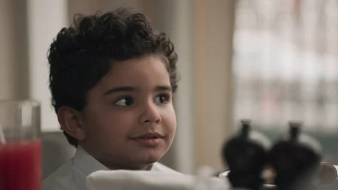 Saudi boy sitting at a dining table. Video stock 105803464