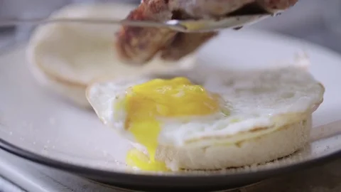 Sausage being placed onto breakfast muffin with egg Stock Footage 85307391