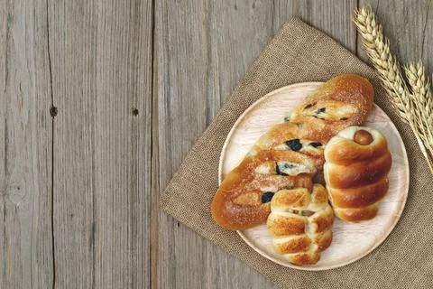 Sausage bread and wheat ears and sack on wooden background,top view Stock Photos