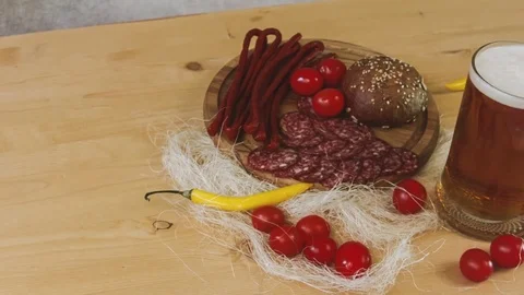 Sausage, chili, cherry tomatoes, bread with glass of beer Stock Footage 84000701