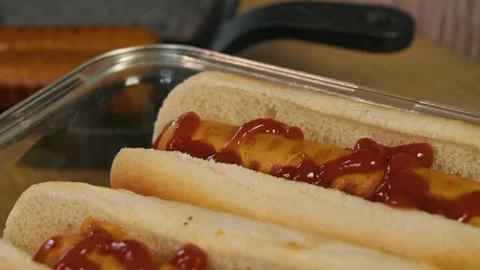 Sausage in hot dogs is generously doused with red ketchup. Close up Stock Footage 304092697