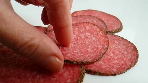 Sausage salami on a white background drops, hand takes Stock Footage 89815768