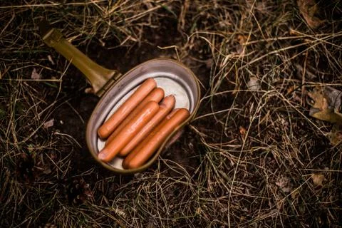 Sausages are fried over an open fire in a pan Stock Photos