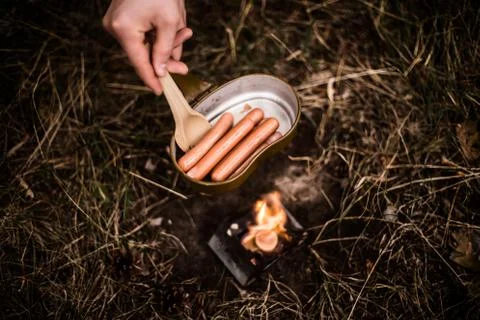 Sausages are fried over an open fire in a pan Stock Photos