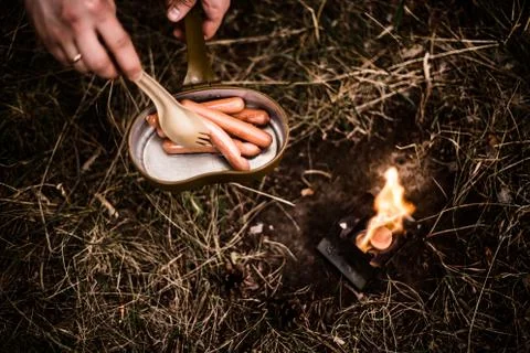 Sausages are fried over an open fire in a pan Stock Photos