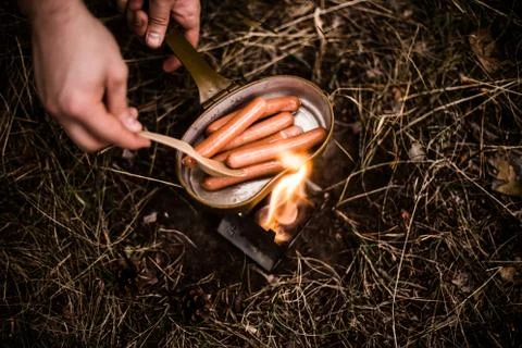Sausages are fried over an open fire in a pan Foto stock