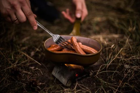 Sausages are fried over an open fire in a pan Photos