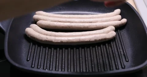 Sausages are placed on the grill pan. food preparation. frying meat. Stock Footage 247500521