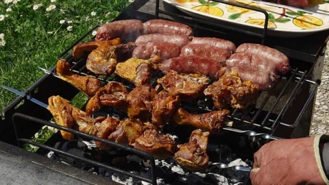 Sausages, chicken and beef getting cooked for summer barbecue, slow motion HD Stock Footage 76557027