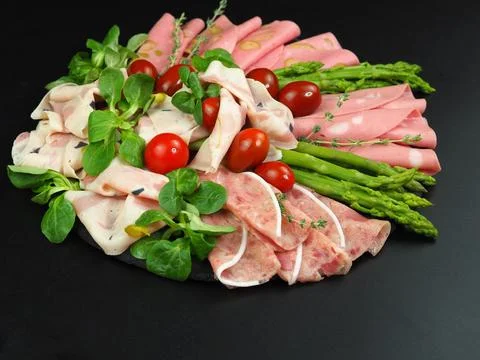 Sausages of different types are thinly sliced and served on a large plate alo Stockfoto's