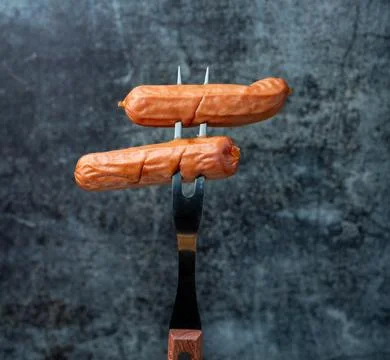 Sausages on a fork Stock Photos