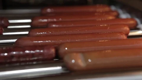 Sausages grilling over the flames. Appetizing hotdog sausages being cooked on gr Stock Footage 76745864