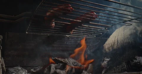 Sausages grilling over open fire barbecue Vídeo Stock 329923521