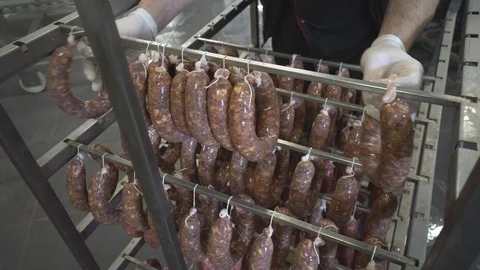 Sausages hanging on a  rack at meat processing factory Stock Footage 124305701