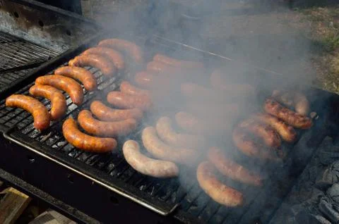 Sausages on the hot grill with smoke Stock Photos