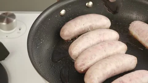 Sausages in a pan being turned Stock Footage 24671759