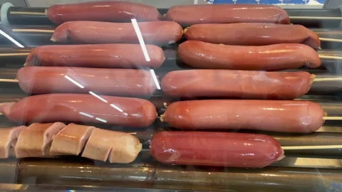 Sausages on a rotating roller grill machine in a convenience store Stockbeeldmateriaal 329613036
