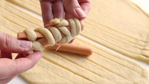 Sausages wrapped in raw dough. Sausage dog mummies. Sausages encased in dough Stockbeeldmateriaal 253866853