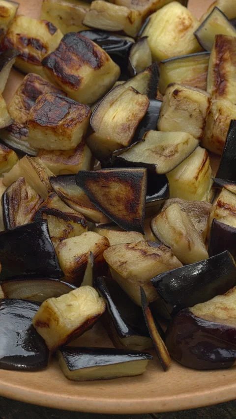Sauteed aubergine chunks on a plate. Table spin. Vertical video. Stock Footage 279261833
