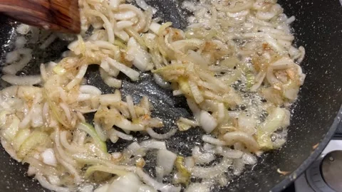 Sauteed chopped onion is sizzling with vegetable oil in a hot non-stick pan.  Video stock 344183274