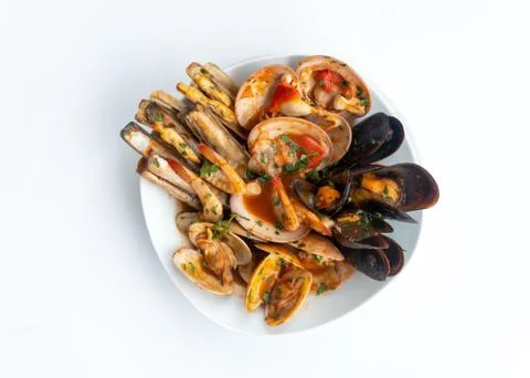 Sauteed shellfish and seafood in a white plate on a white background Foto stock