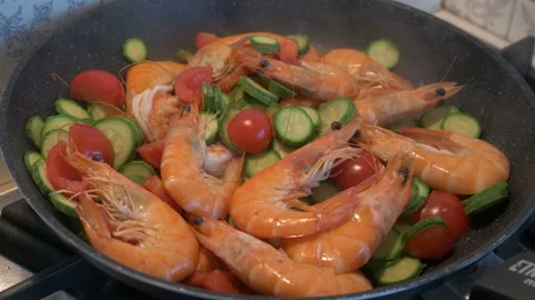 Sauteed shrimp, courgettes, and cherry tomatoes, in a steaming pan Stock Footage 199778382