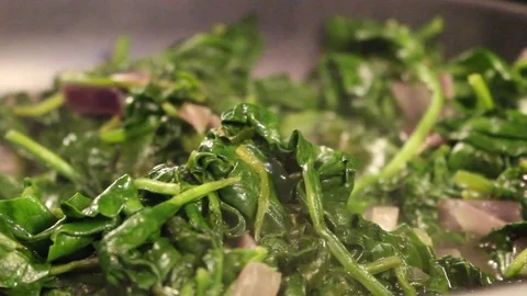 Sautéeing spinach - Arty close up Stock Footage 96475839