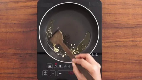 Sauteing Garlic and Adding Tomato Puree 動画素材 76997626