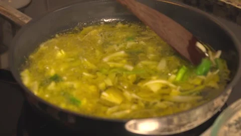 Sauteing leeks and spring onions in sizzling olive oil Stock-Footage 331313947