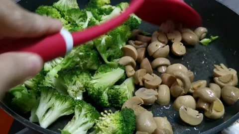 Sauteing Mushroom with Broccoli at the Side Stock Footage 234882913