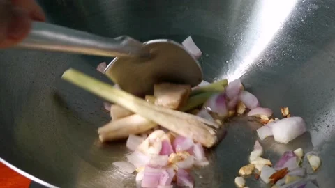 Sauteing Onion, Garlic, Smashed Chopped Ginger and Lemongrass Stalk Stock Footage 236774853