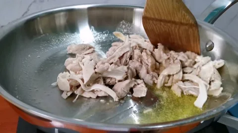Sauteing Shredded Chicken in a Pan Video stock 158076361