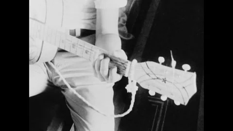 SAVANNAH - 1965: 1st Cav Deployment - Guitar strings up close 库存影片 344002581