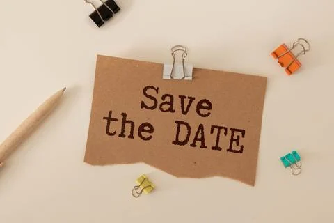 Save the date message written on ripped torn paper on green background. Stock Photos