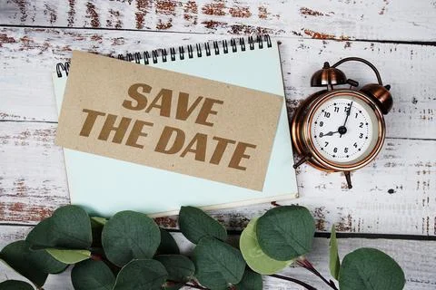 Save the Date text message on paper card with flowers border frame on woode.. Stock Photos