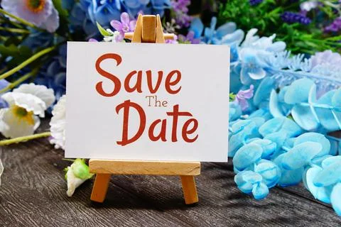 Save the date text write on paper card with wooden easel and flowers decora.. Stock Photos