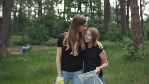 Save the environment. Happy sisters with plastic bags hugging kissing together Stock Footage 112750592