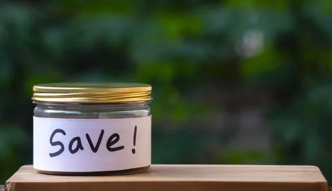 Save Label Jar on Wooden Table for Money Saving Concept Stock Photos