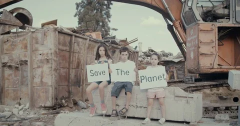 Save the planet. three kids holding signs standing in a huge junkyard 스톡 동영상 80807021