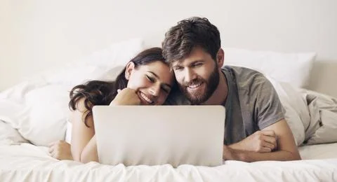 Save some time everyday to connect. Shot of a happy young couple using a lapt Fotos Stock