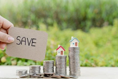 Save word paper with house on stack of coin on blurred green natural backgrou Stock Photos