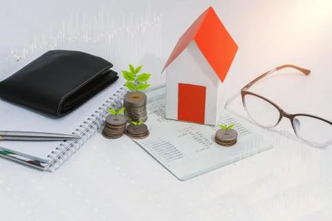 Saving account passbook or financial statement, paper house model, and coins Stock Photos