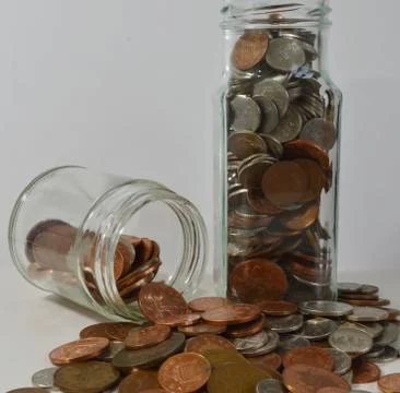 Saving up with coins in jars Stock Photos