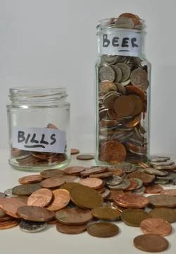 Saving up with coins in jars Stock Photos