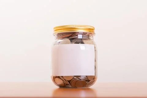 Saving Coins, Saving Money. Save Coin in Jar with Blank white label Stock Photos