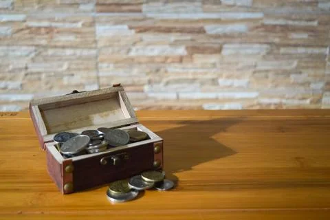 Saving concept. Angle view of coins and chest box on the table Stock Photos