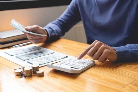 Saving concept the guy in the dark blue sweater working on counting cashes an Foto stock