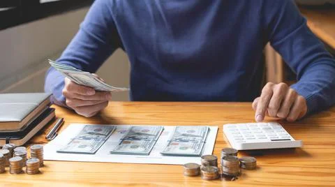 Saving concept the guy in the dark blue sweater working on counting cashes an Stock Photos