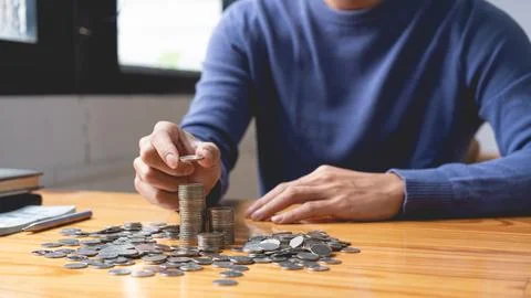 Saving concept the guy who wears deep blue pullover counting his saving coi.. Foto stock